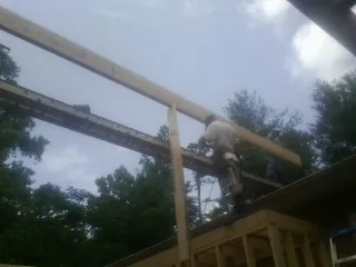 Carpenter setting a ridge beam over a new addition frame — Ice Dam Removal by Roofing Brothers in Rolling Prairie