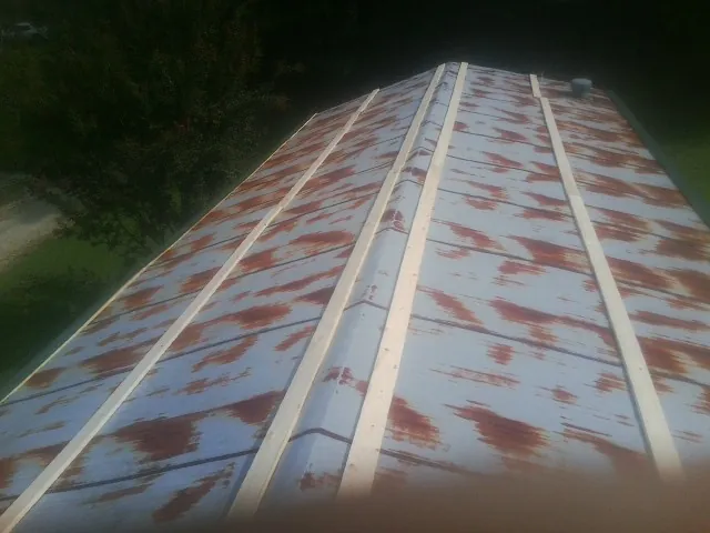 Rusted metal roof panels with new wood purlins before replacement — Storm Damage Roof Repair in Rolling Prairie by Roofing Brothers