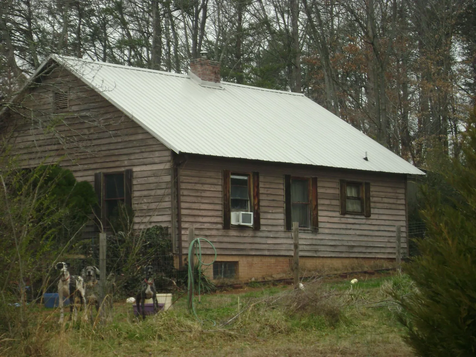 White metal roof on an old wood sided farmhouse, from a Metal Roof Installation job in Rolling Prairie